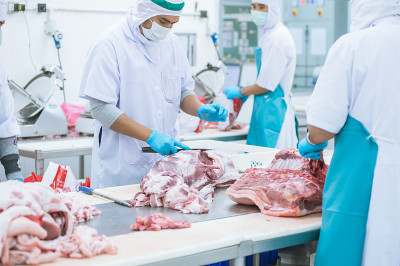 在工厂里切肉的工人