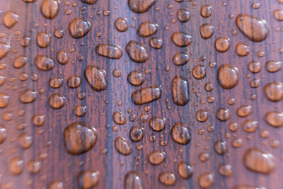 雨滴落在金属板上。带露珠的棕色金属板。