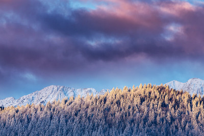 冬天的风景在山上，有白雪覆盖的山峰和落日的月亮
