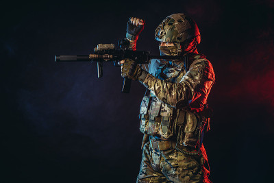 身着制服的士兵用步枪指着烟雾弥漫的空间