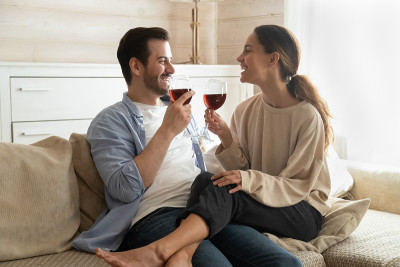 千禧家庭坐在沙发上，拿着酒杯庆祝结婚纪念日