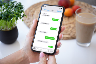 女性手拿手机，屏幕上有应用程序messenger