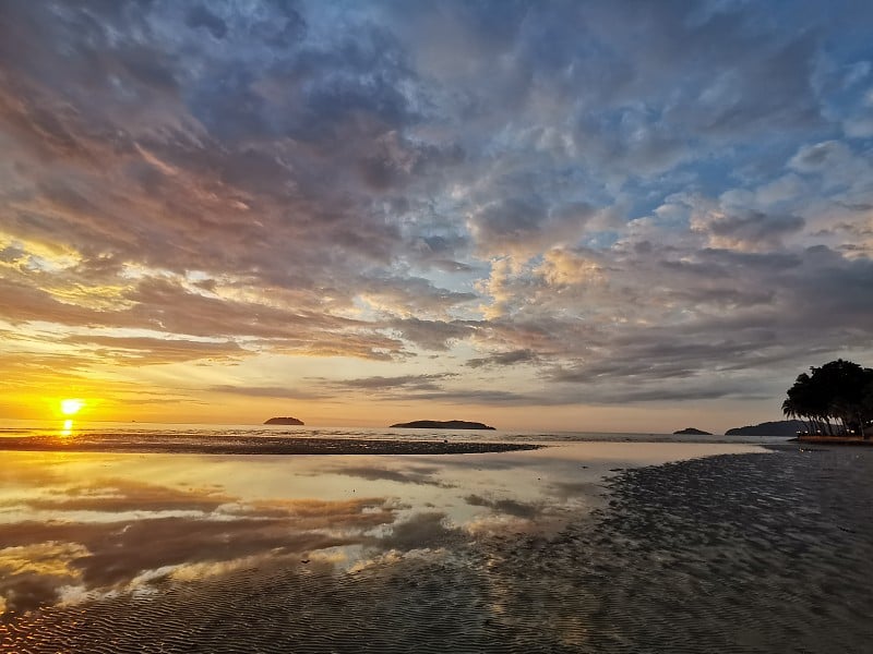 特写与美丽的日落在丹戎阿鲁海滩，哥打基纳巴卢。马来西亚沙巴,。婆罗洲。《风下的土地》。