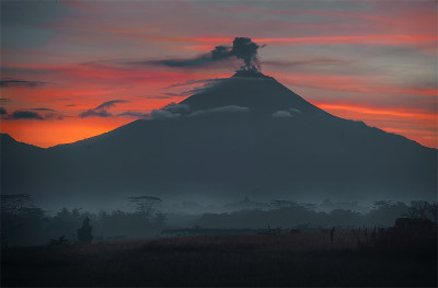 默拉皮火山喷发时的大气和下面的婆罗浮屠寺庙在早晨有薄雾