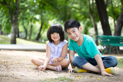 一个亚洲小孩在公园里玩沙子