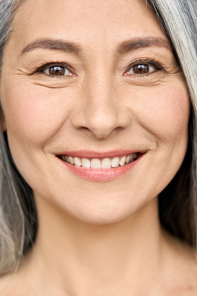 特写亚洲微笑成熟女人与完美的自然妆容。