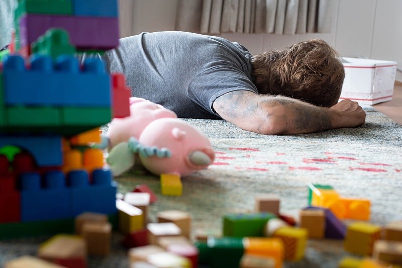 Tired dad taking a nap in a messy home. Parenthood