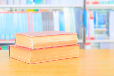 学校图书馆的旧书和堆论文放在桌子上。模糊的书架背景。教育学习理念用拷贝空格加文字