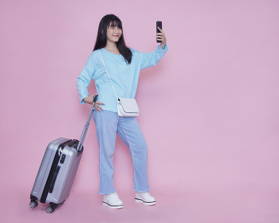 带着行李箱和智能手机的女人夏天旅行