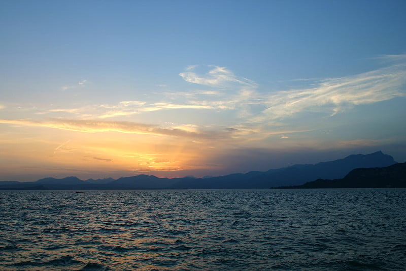 湖与游艇在美丽的日落天空的背景