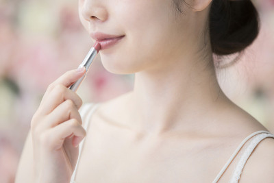 亚洲(日本)年轻女子在嘴唇上涂红色的口红