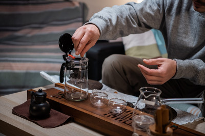 家中茶道的过程。茶艺师将几片生的陈年红茶放入竹盘上的茶壶中