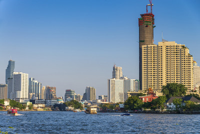 曼谷城市天际线以河流和蓝天为背景，曼谷是泰国的现代大都市，深受游客的喜爱