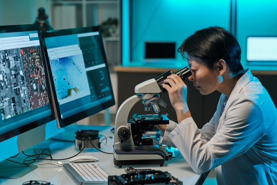 亚洲女科学家在显微镜观察调查