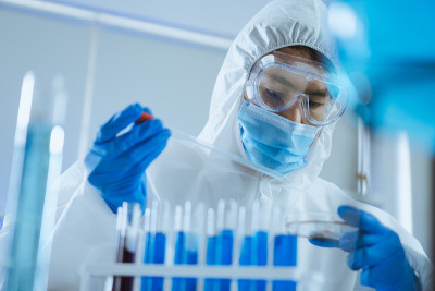年轻的科学家跌落和摇动生物化学培养皿混合和在实验室里查看。医生和科学家在covid - 19概念的冠