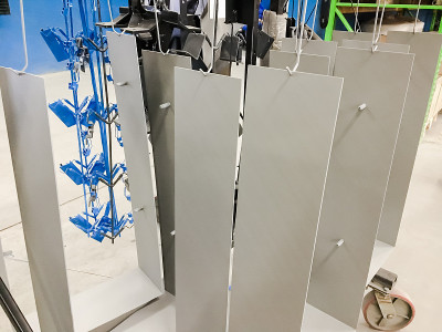 粉末涂料。金属板悬挂在架空的传送带上。涂料产品在静电场中。