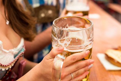 一对年轻夫妇在啤酒节的啤酒帐篷里敬酒