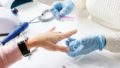 Manicure master using a brush to swipe the dust af