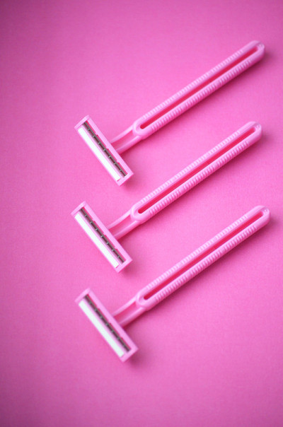 Three isolated pink plastic female razors for sing