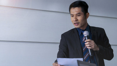 商人是一个演讲者，在会议室、研讨会和会议上向观众和企业家展示和交谈，简要介绍工作和项目。