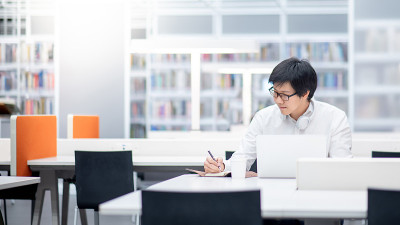 亚洲人大学学生在图书馆使用笔记本电脑