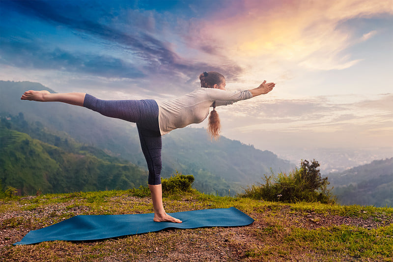 女人做阿斯汤加串联瑜伽体式Virabhadrasana 3勇士