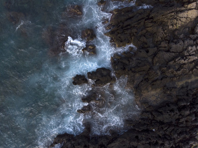 空中向上向下的图像，海浪溅起白色泡沫的岩石，岩石悬崖，海岸，克里特岛，希腊。海的图案，背景墙纸。