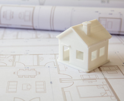 建筑的概念。办公桌上有住宅建筑图纸和建筑房屋模型