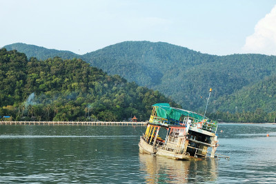 船沉在海中，以岛屿为背景。关注船