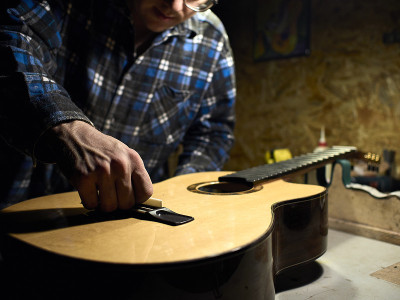 在吉他工作室，Guitars Luthiers安装一个马鞍。