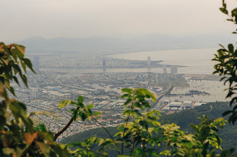 越南岘港海凡山口顺化的琅哥海滩全景。火车在海边的铁路上行驶，绿色的森林，美丽的自然景观，海浪