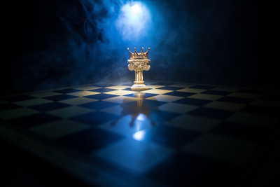 棋盘游戏概念的经营理念和竞争理念以及战略理念。象棋人物在黑暗的背景与烟和雾，窗户与阳光。有选择性的重