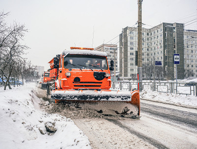 铲雪车在下雪时清除城市道路表面的冰雪。冬天，下雪，交通拥挤。