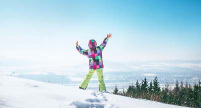 快乐的小女孩在雪山上跳跃