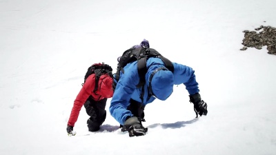 登山者到达白雪覆盖的山峰