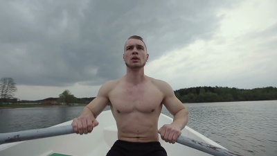 在船上漂浮的肌肉强壮的男人。慢动作。