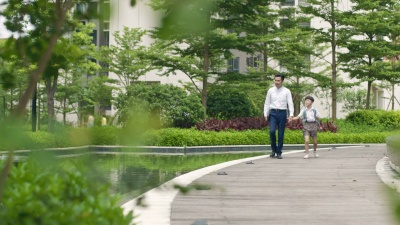 亚裔父亲护送儿子在花园慢动作上学