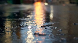 夜里，城市街道上的雨以慢动作落下。