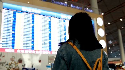 女旅客在机场查看航班信息屏幕