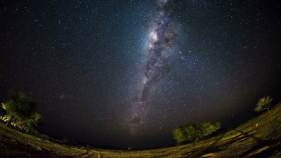 纳米比亚纳米布沙漠山脉外明亮的银河系和星空的明显旋转。鱼眼视图。延时视频。
