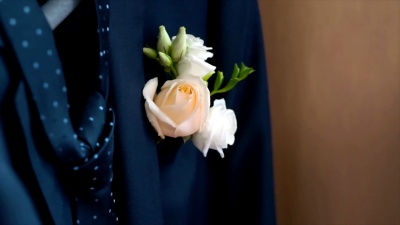 新郎结婚那天夹克口袋里的boutonniere。剪辑。他上衣口袋里的玫瑰