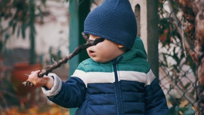 秋天的一天，蹒跚学步的男孩在花园里玩耍。慢动作拍摄