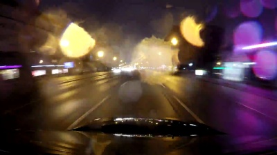 快速城市行驶夜间道路POV时间推移的挡风玻璃和车罩，雨夜，雨滴在玻璃上