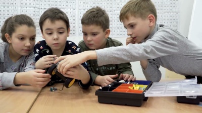 可爱的孩子们在小学建造电动机器人的镜头