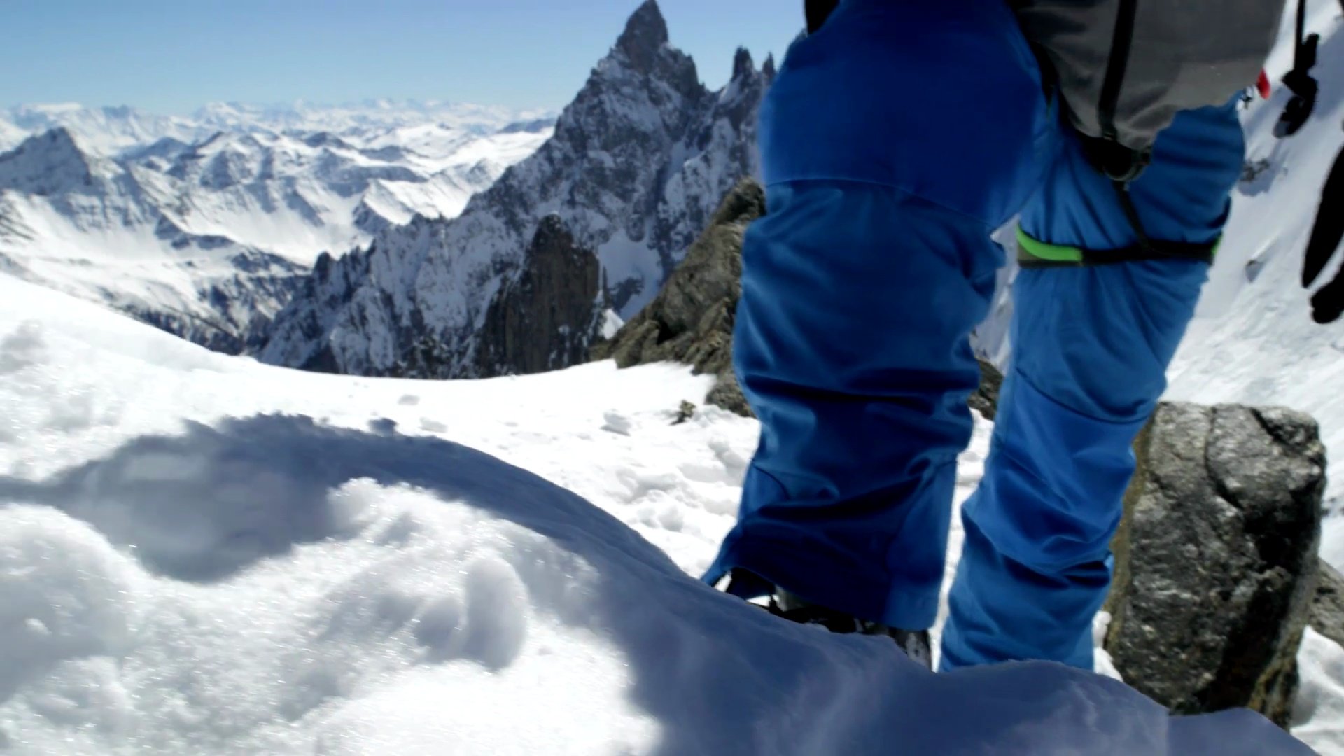 登山者男子在晴天在雪山顶附近使用冰斧。登山滑雪活动。滑雪者人们在高山户外进行冬季雪上运动。后视图。慢速运动60p  视频