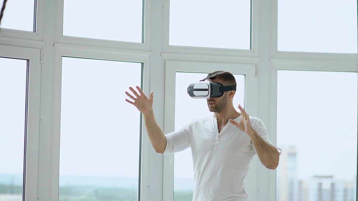 年轻人拥有虚拟现实头盔的VR体验，使用手势进行控制
