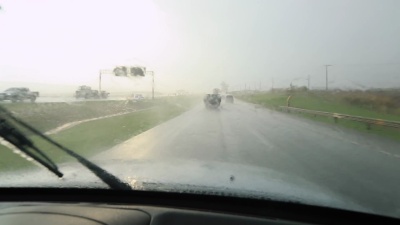 带着挡风玻璃的雨天公路旅行的POV。在雨中开车 