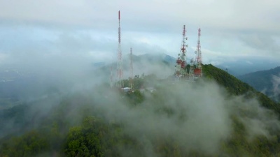 城市上空山上有雾的通信桅杆电视天线的鸟瞰