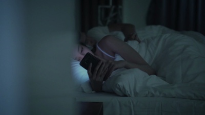 女人在床上用智能手机拍多莉