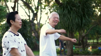 亚洲老年夫妇在公园跳舞进行有氧运动。一起欢笑和快乐